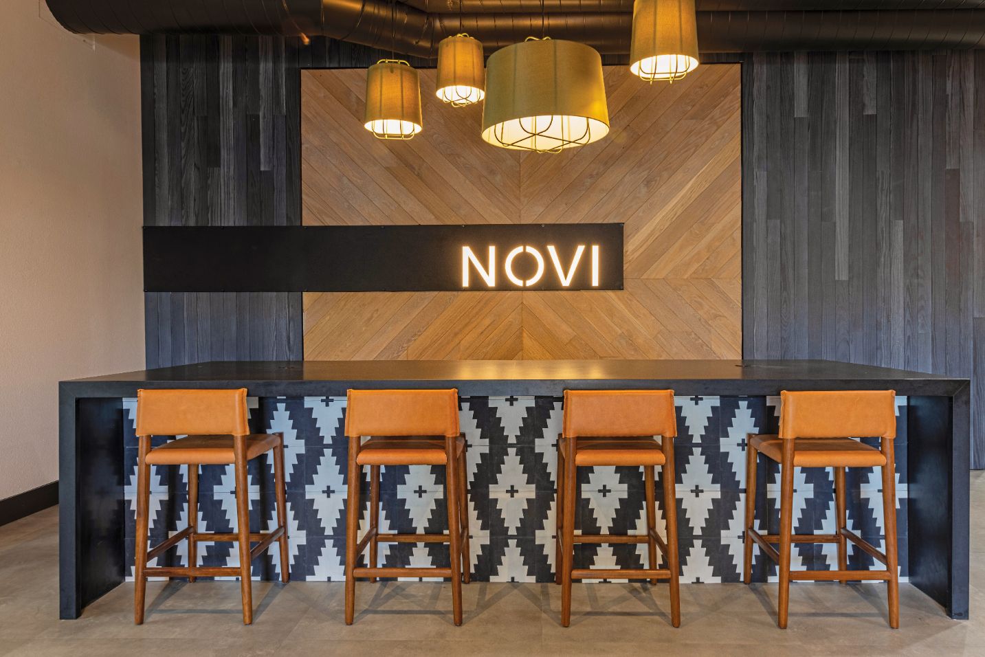 indoor clubhouse with black serving and and wooden backdrop, light up Novi logo sign